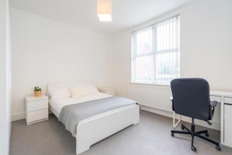 Bright and clean master bedroom featuring a com...