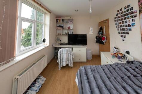 A cozy single bedroom featuring a large window ...