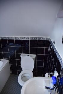 A tidy bathroom suite featuring a white toilet,...