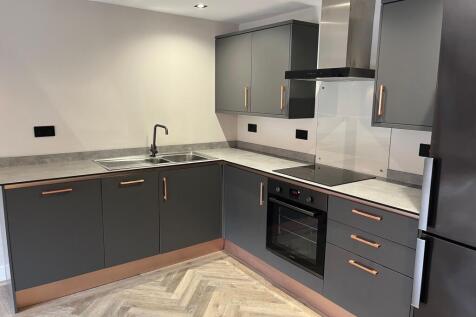 A modern kitchen featuring sleek grey cabinets ...