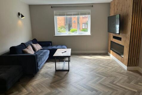 A modern and tidy living room featuring a styli...