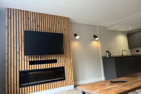 A modern living room featuring a stylish wooden...