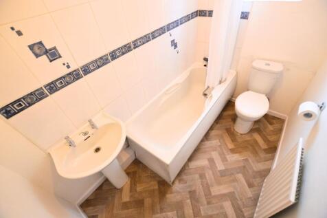 A bright bathroom featuring a clean white batht...