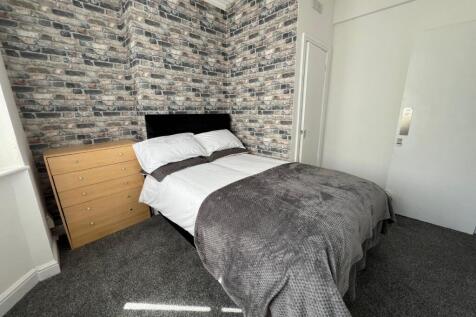 A stylish double bedroom featuring a cozy bed w...