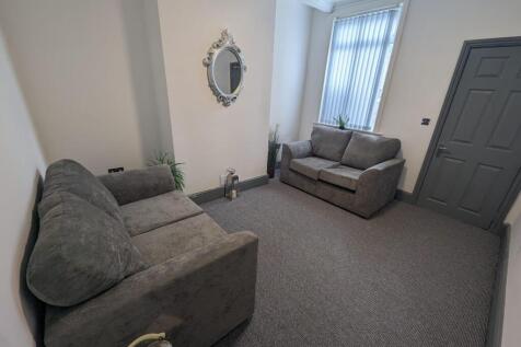 A cozy living room featuring two comfortable gr...