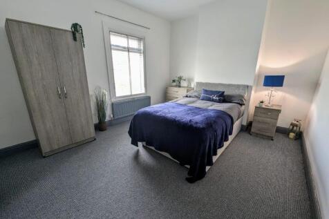 A bright and tidy double bedroom featuring a do...