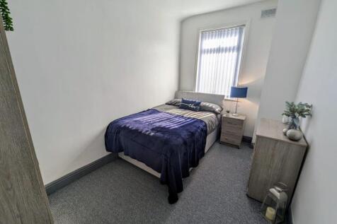 A neatly arranged double bedroom featuring a co...