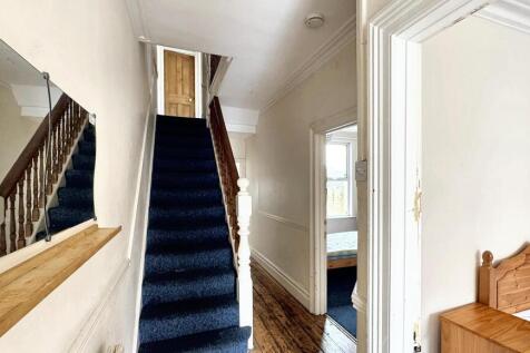 Bright and tidy hallway featuring polished wood...