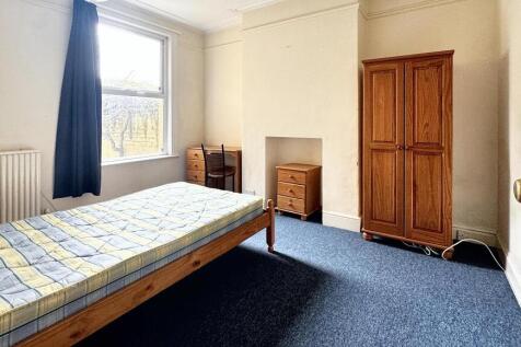 A bright and tidy single bedroom featuring a la...