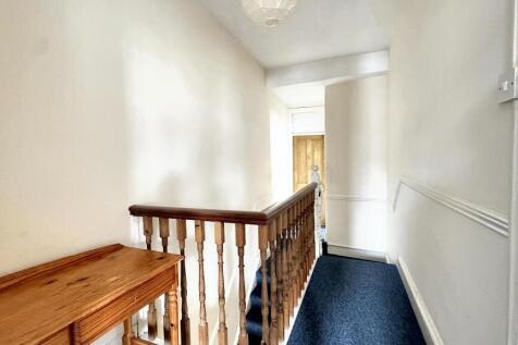 Bright and clean hallway featuring a wooden ban...