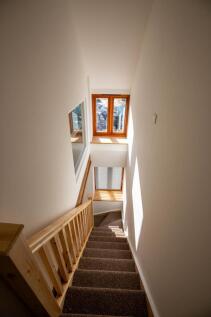 A bright and clean staircase featuring wooden h...