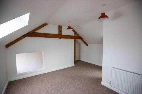 A clean and bright attic bedroom featuring whit...