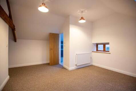 A clean and cozy single bedroom featuring warm ...