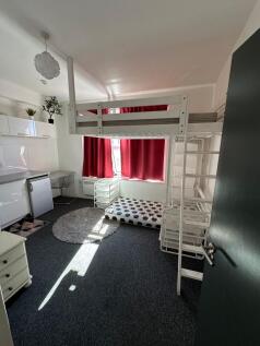 A bright and functional student bedroom featuri...