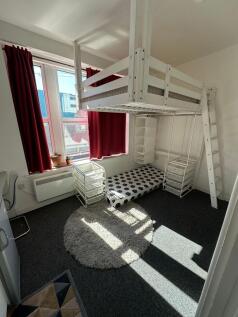 Bright and tidy student room featuring a top bu...