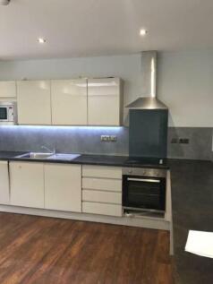A modern kitchen featuring sleek white cabinetr...