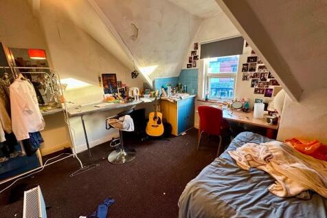 Cozy attic-style bedroom featuring natural ligh...