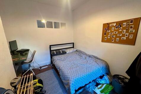 Cozy single bedroom featuring a comfortable bed...