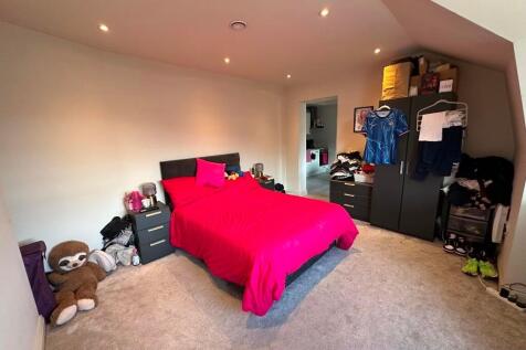 A spacious master bedroom featuring a bold red ...