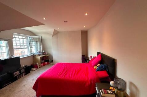 A spacious master bedroom featuring a comfortab...