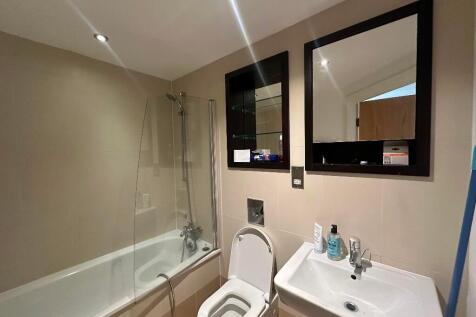 Bright and modern bathroom suite featuring a ba...
