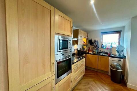 Bright kitchen featuring wooden cabinetry, buil...