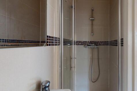 A modern bathroom featuring a clean walk-in sho...