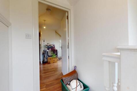 A bright hallway with white walls and a wooden ...