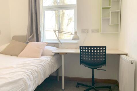 A bright and tidy single bedroom featuring a co...