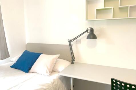 A bright and tidy single bedroom featuring a co...