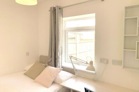 A bright and tidy single bedroom featuring a ne...