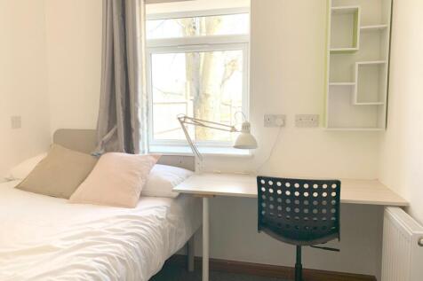 A bright and tidy single bedroom featuring a co...
