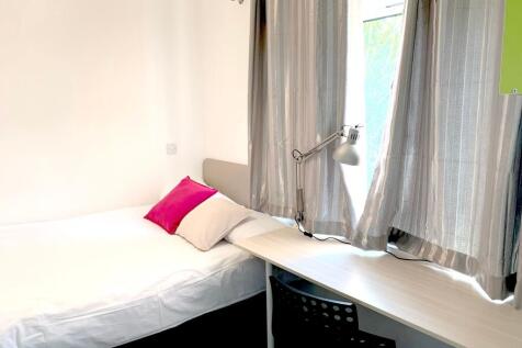 A bright and tidy single bedroom featuring a co...
