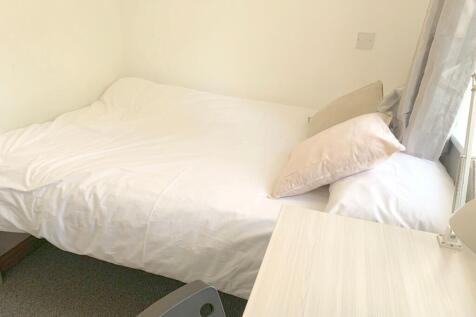 A bright and tidy single bedroom featuring a ne...