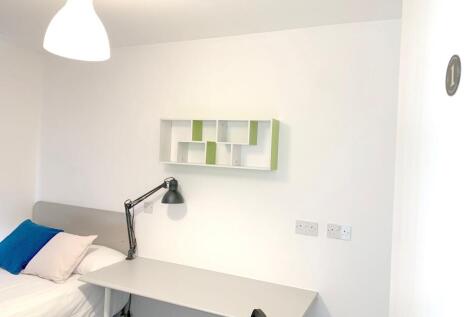 A tidy and minimalist single bedroom featuring ...