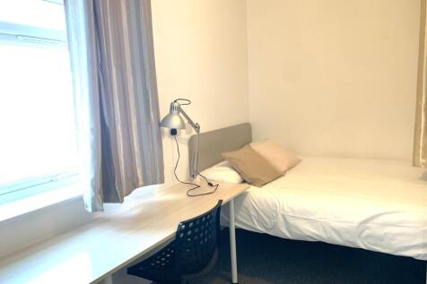 A neat and bright single bedroom featuring a co...