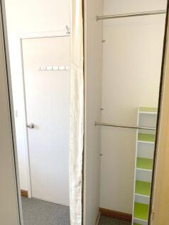 A clean and bright storage area with a white do...