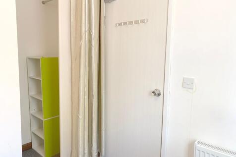 Bright and tidy hallway featuring a white door ...