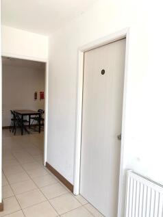 Bright and clean hallway with tiled floors and ...