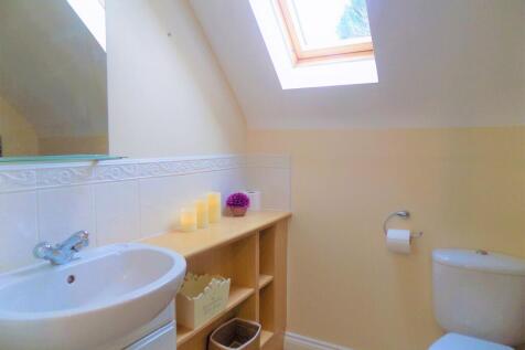 A bright and tidy bathroom with a skylight wind...