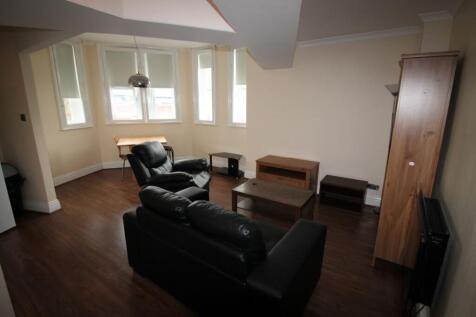 A modern living room with dark wooden flooring ...