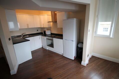 A bright and modern kitchen featuring white cab...