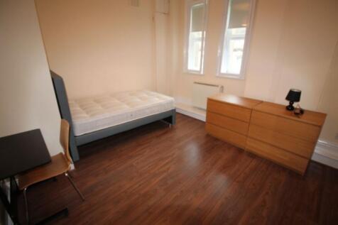 A neat and well-lit bedroom featuring a single ...