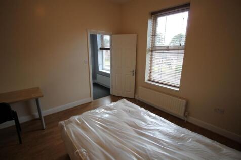 A tidy double bedroom featuring a large window ...