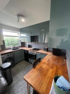 A modern kitchen featuring stylish teal cabinet...