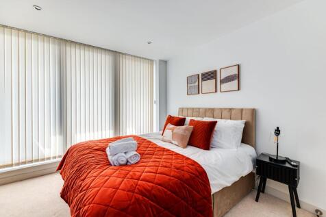Bright and welcoming master bedroom featuring a...