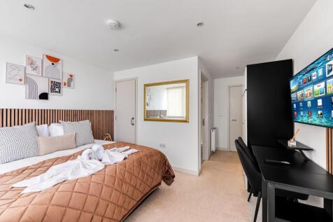 Bright and modern master bedroom featuring a la...