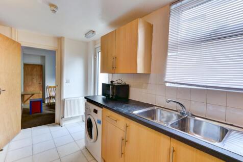 Bright and tidy kitchen featuring light wood ca...
