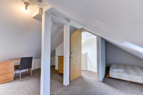 Bright and cozy attic bedroom featuring a desk ...