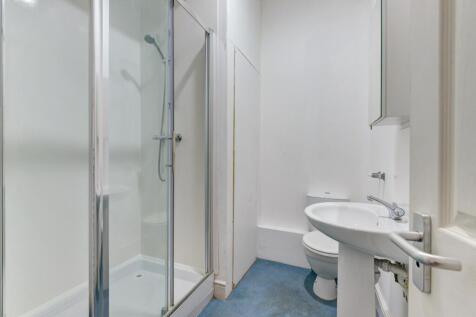 A clean and modern bathroom featuring a glass-e...